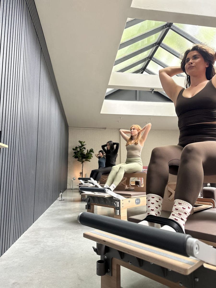 Drie deelnemers op de reformer